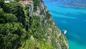 A coastal village with a church, steep cliffs, and a clear blue sea.
