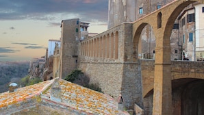 A historic stone bridge with arches, a tower, and buildings with balconies. - L'Altro Sapore Rooms (Pitigliano)