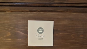 A wooden panel with a sign indicating "Oivia ROOM". - L'Altro Sapore Rooms (Pitigliano)