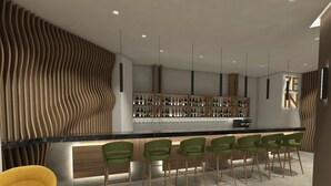 Zona de bar moderna con pared de madera curvada, mostrador de bar y taburetes verdes.