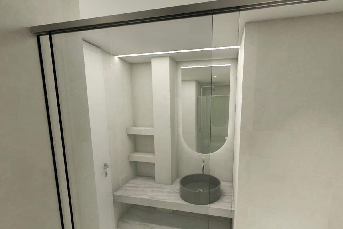 A modern bathroom with a glass-enclosed shower, a round sink, and built-in shelves.