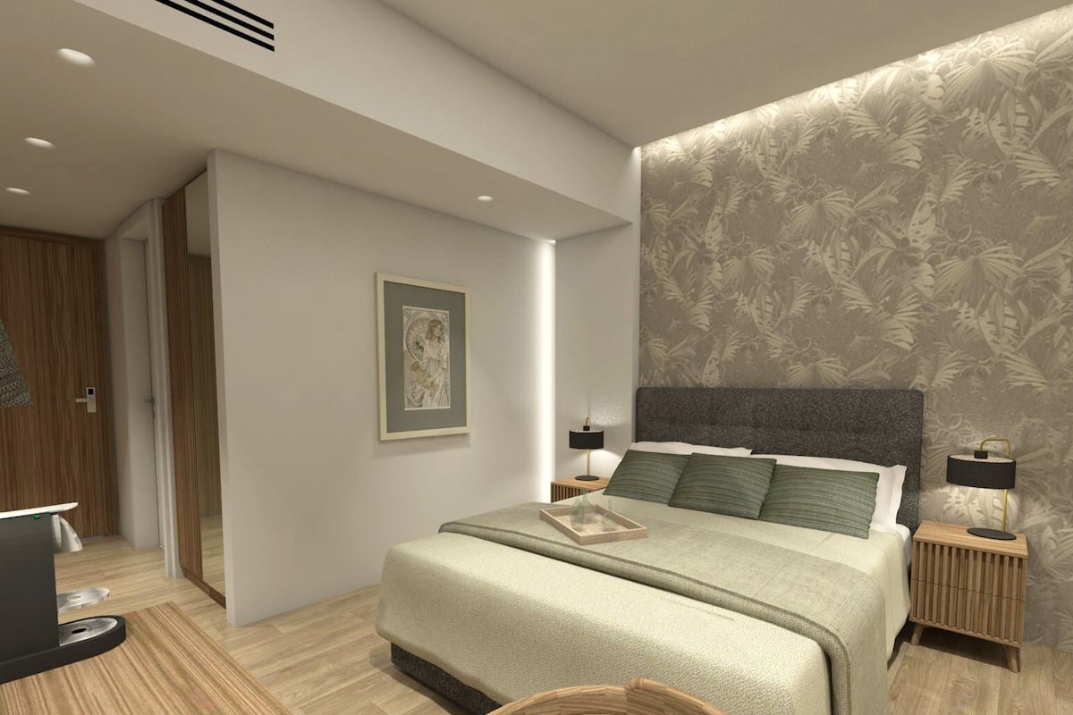 A modern bedroom with a large bed, two bedside tables, a nightstand, a framed picture on the wall, and a door leading to another room.