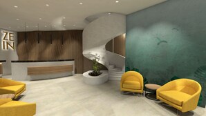 Una zona de recepción moderna con un muro curvo, un mostrador de recepción y dos sillones amarillos.