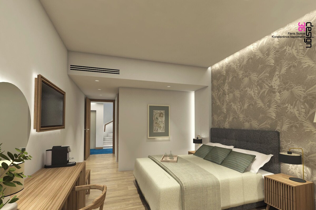 A modern bedroom with a large bed, bedside tables, a desk, and a chair. There is a staircase leading to an upper floor.