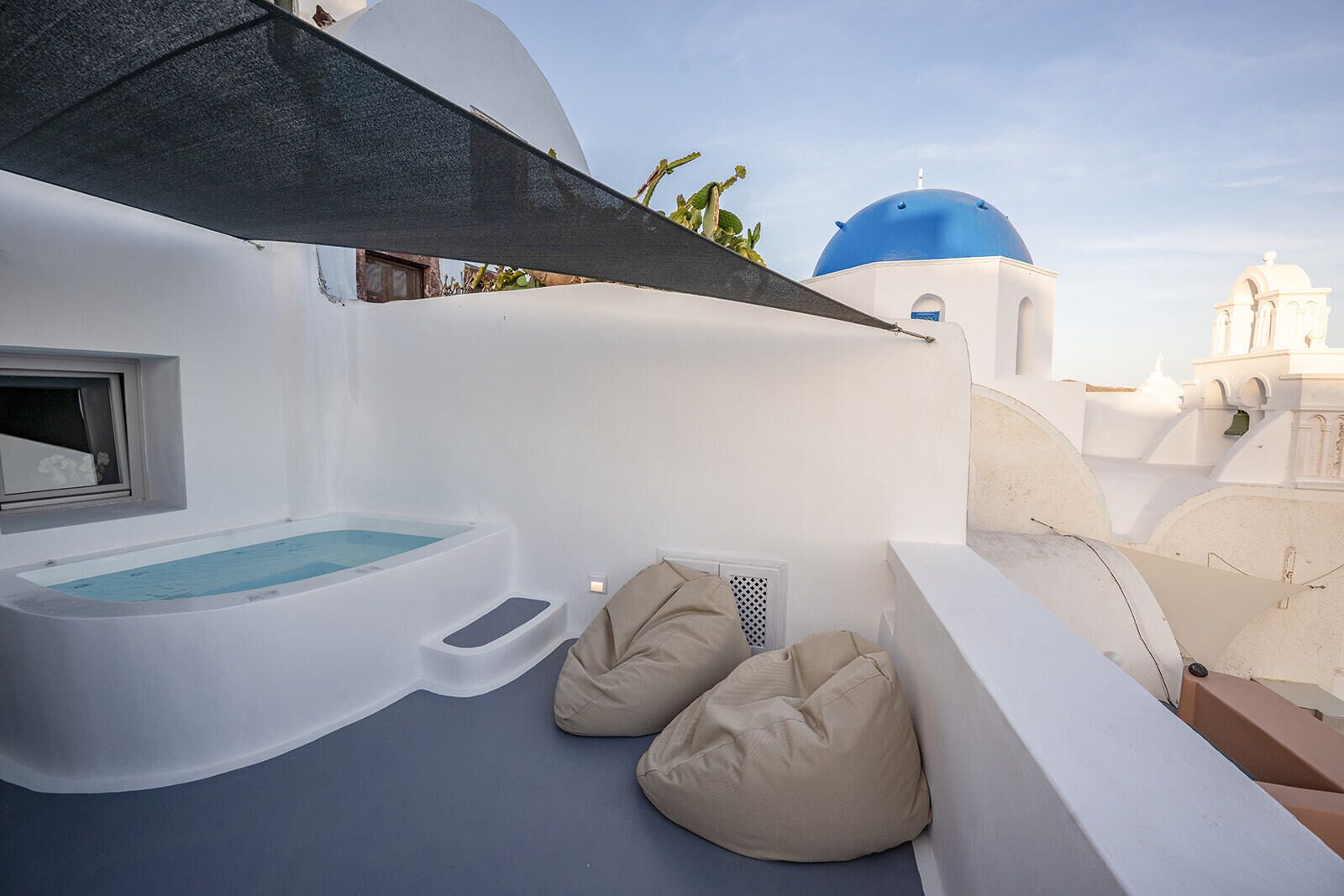 Een dakterras met een jacuzzi, een trap en twee loungestoelen.