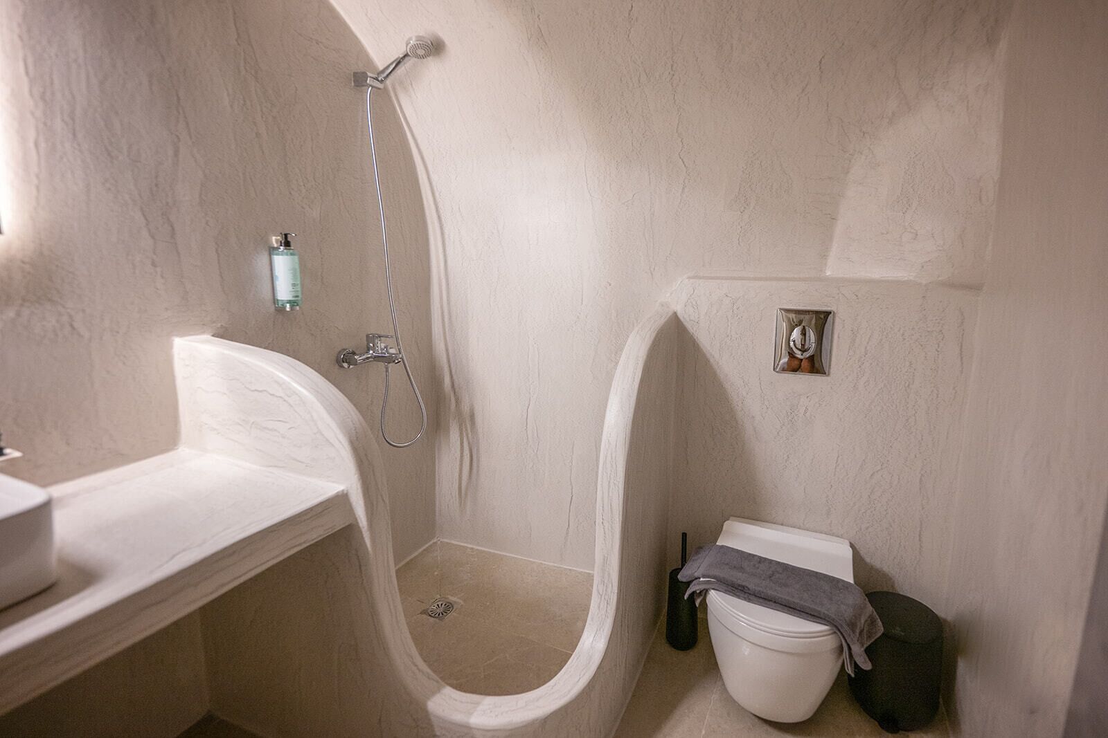 Un baño pequeño con ducha, inodoro y lavabo.