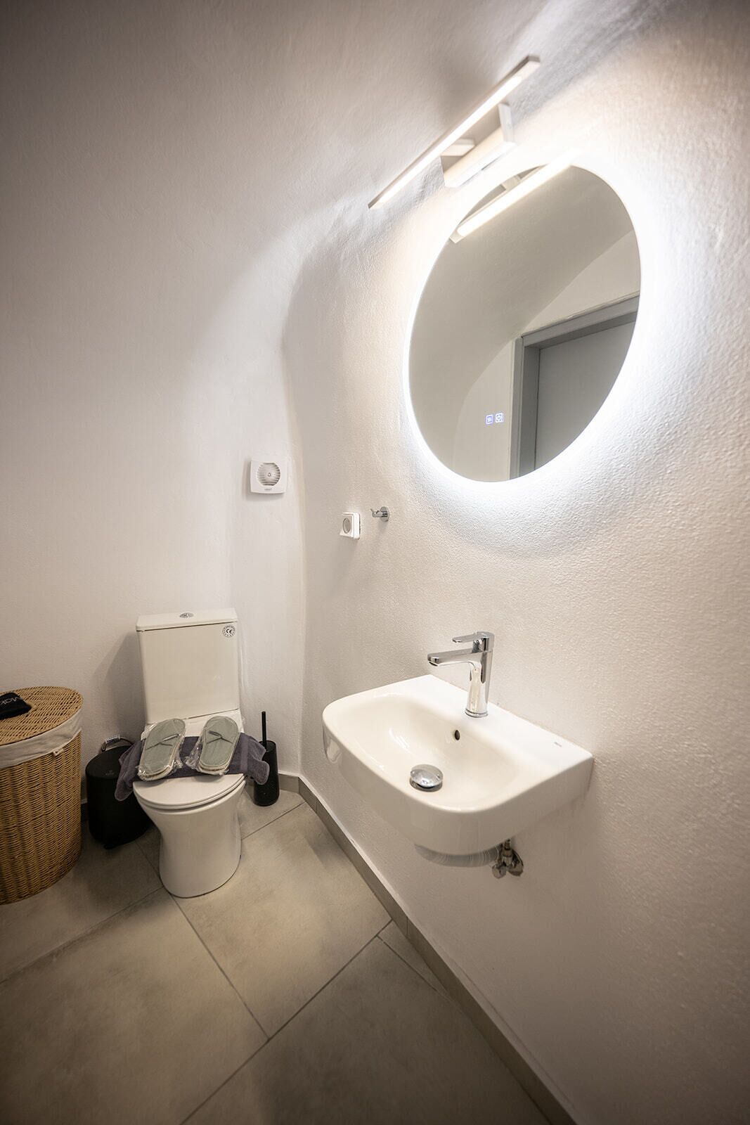 Un bagno con il water, un lavandino e uno specchio.