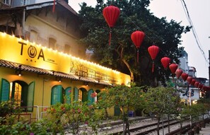 A yellow building with green shutters and a sign that reads "TOA COFFEE". - Homestay-Kim Mã -Giang Văn Minh (Hanoi)
