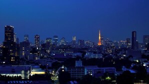 A city skyline at night with illuminated buildings and a prominent tower in the center. - Deluxe Triple Room hotel with AC, fitness room, WiFi in amazing Minato City (Minato City)