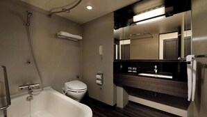 A modern bathroom with a bathtub, toilet, and vanity with a mirror. - Deluxe Triple Room hotel with AC, fitness room, WiFi in amazing Minato City (Minato City)