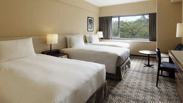 A hotel room with three beds, a small table, and a chair. - Deluxe Triple Room hotel with AC, fitness room, WiFi in amazing Minato City (Minato City)