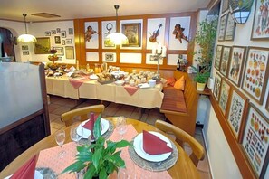 A dining area with a long table set for a meal, surrounded by chairs.