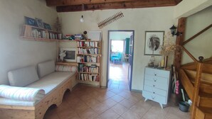 Ein gemütliches Zimmer mit einer hölzernen Bank, einem Bücherregal, einem Schreibtisch und einer Treppe.