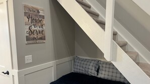 A bedroom with a bed, a staircase, and a motivational quote on the wall.