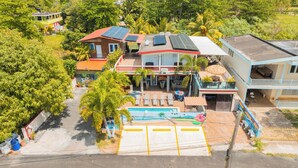 A multi-story building with a swimming pool, solar panels, and a balcony with a view of the pool. - Vacation Home for 20 Guests with 2 Private Pools (Aguada)