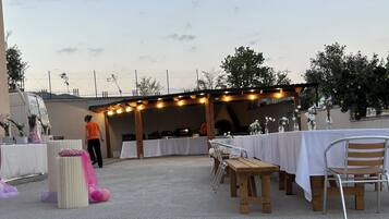 An outdoor event space with tables set up for dining, a stage area, and a seating arrangement.