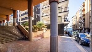 Um edifício residencial de vários andares com um pátio central, área de estar ao ar livre e escadaria que leva aos pisos superiores.