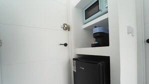 A compact kitchenette with a black refrigerator, a microwave, and a coffee maker. - Brisas del Poniente-Deluxe Room Ocean View (Benidorm)