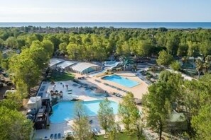 Oversigtsbillede af et resort med flere swimmingpools, en vandpark og frodig vegetation.