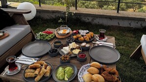 Mesa al aire libre con diversos alimentos y una vista panorámica de fondo.