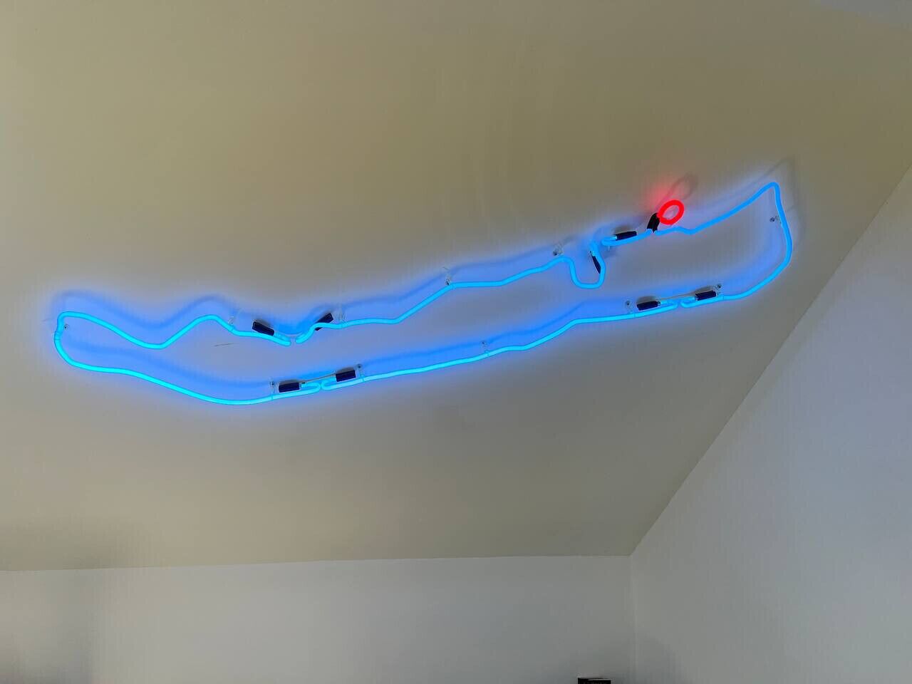 Un soffitto con un'installazione luminosa al neon blu.