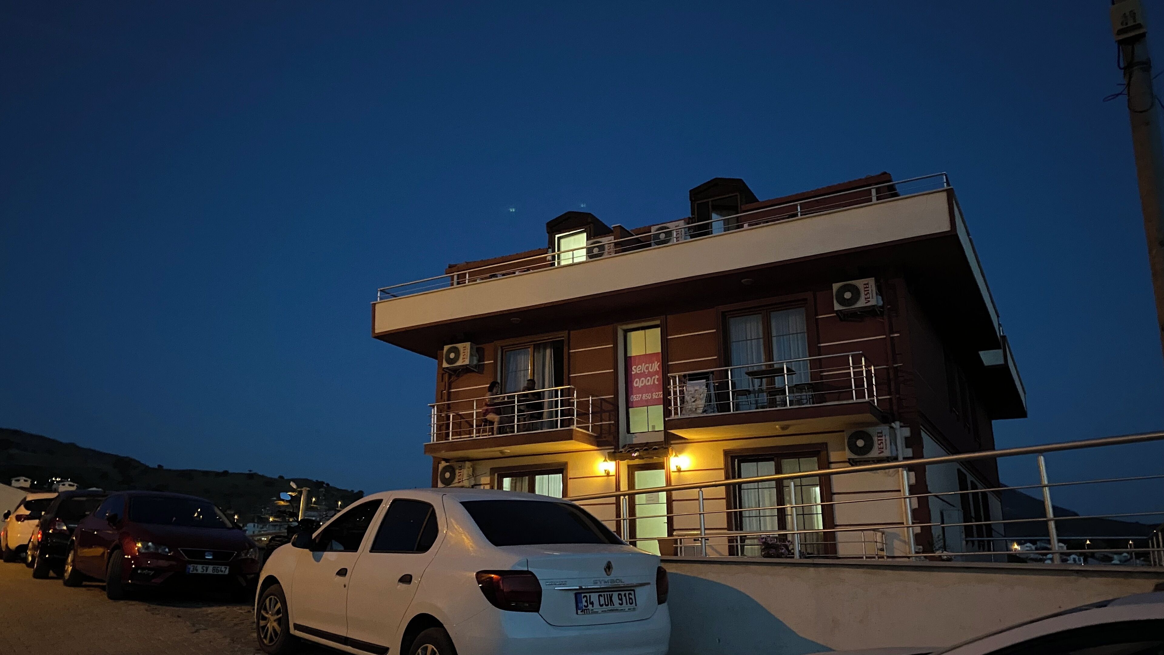 Un immeuble à plusieurs étages, doté de balcons, de climatiseurs et d’une enseigne indiquant qu’il s’agit d’un immeuble d’appartements.