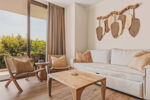 Una sala de estar moderna con un sofá, dos sillones de mimbre, una mesa de centro de madera y un adorno fijado a la pared.