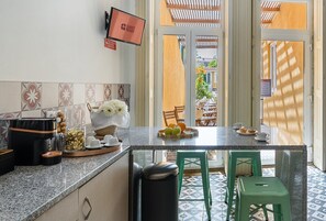 Una cocina con encimera de granito, una cafetera y un cuenco con flores.