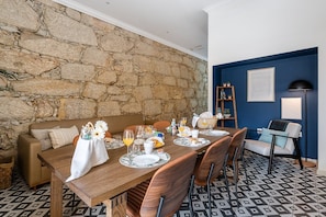 A dining area with a stone wall, a blue accent wall, and patterned floor tiles.