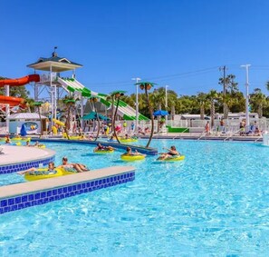 A swimming pool with water slides and inflatable rafts.