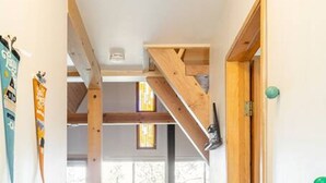 Un couloir étroit avec un escalier menant à un espace de vie, une cuisine et une salle à manger.