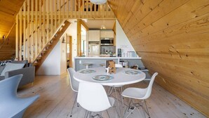 Un intérieur en bois comprenant un coin repas, une cuisine et un escalier.