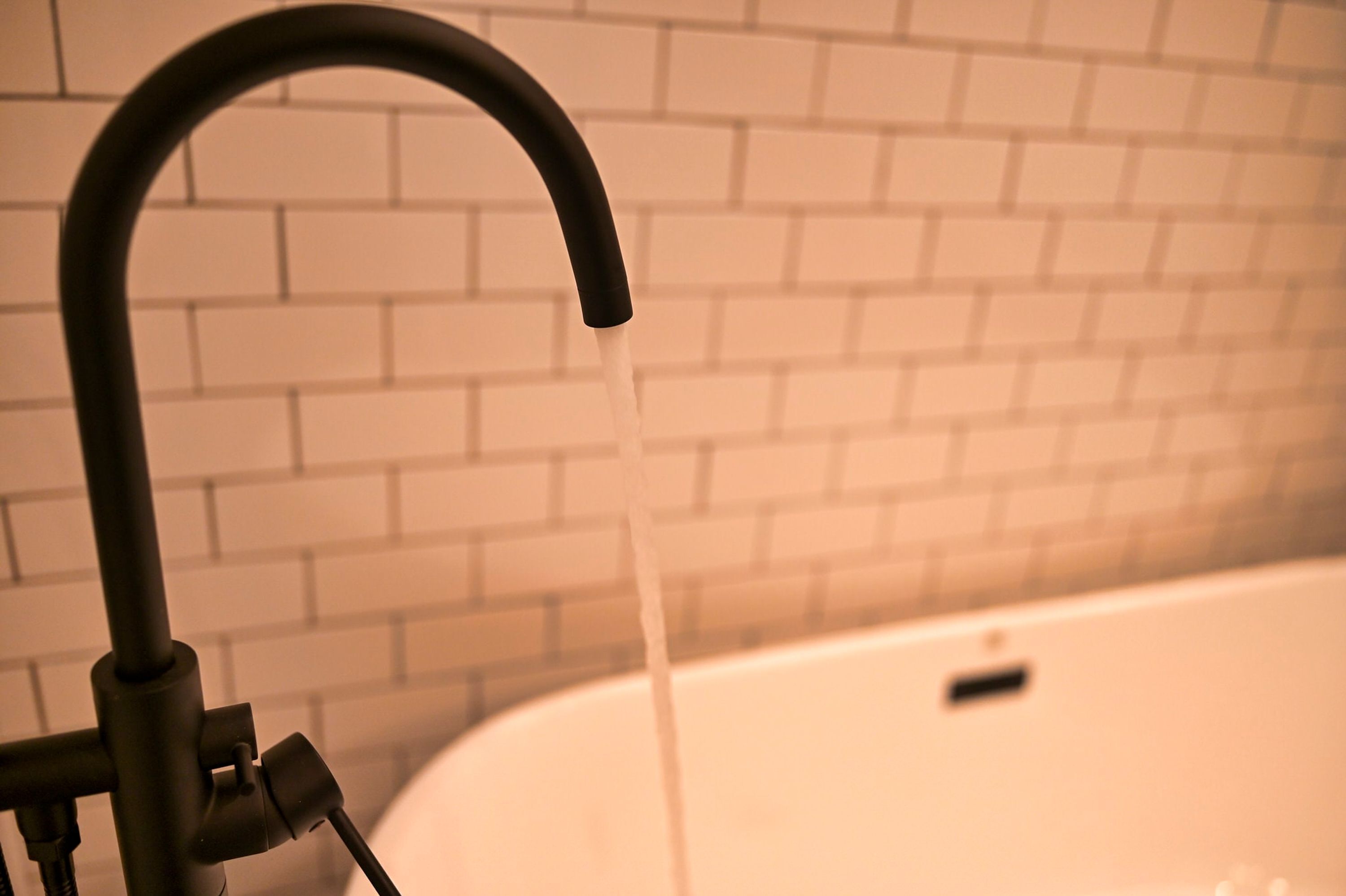 A bathroom with a white bathtub and a faucet.