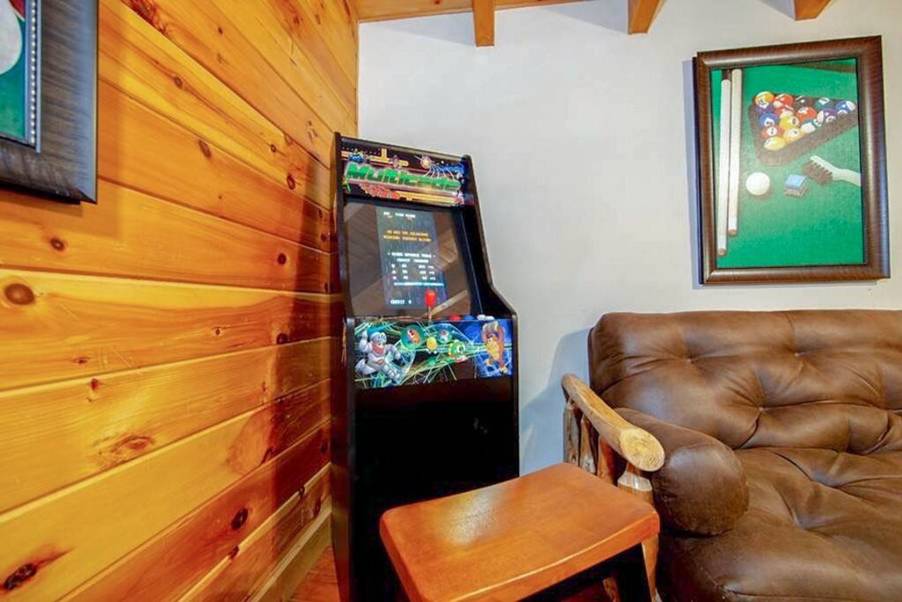 Ein Billardtisch mit Queue und Kugeln, ein Holzbilliardtisch und ein braunes Ledersofa.