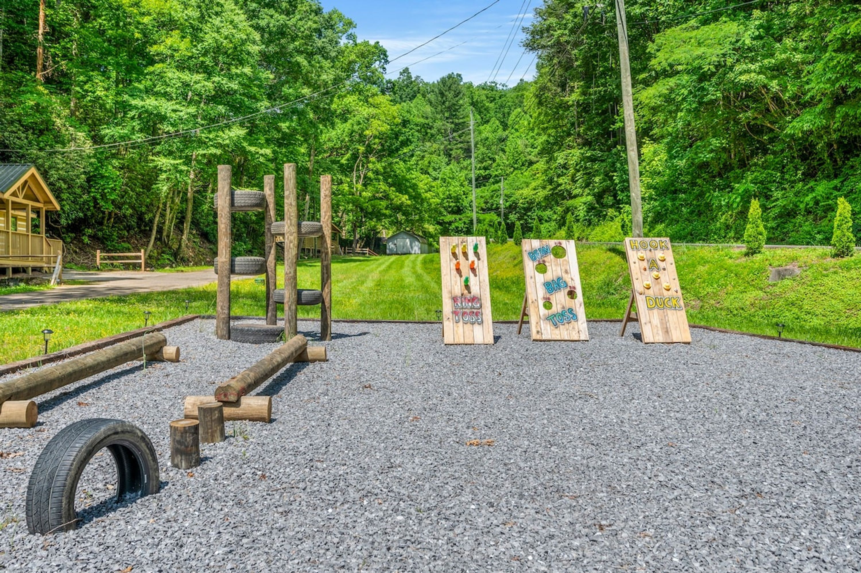 Ein Spielplatz mit Holzkonstruktionen und einer Reifenhindernisbahn.