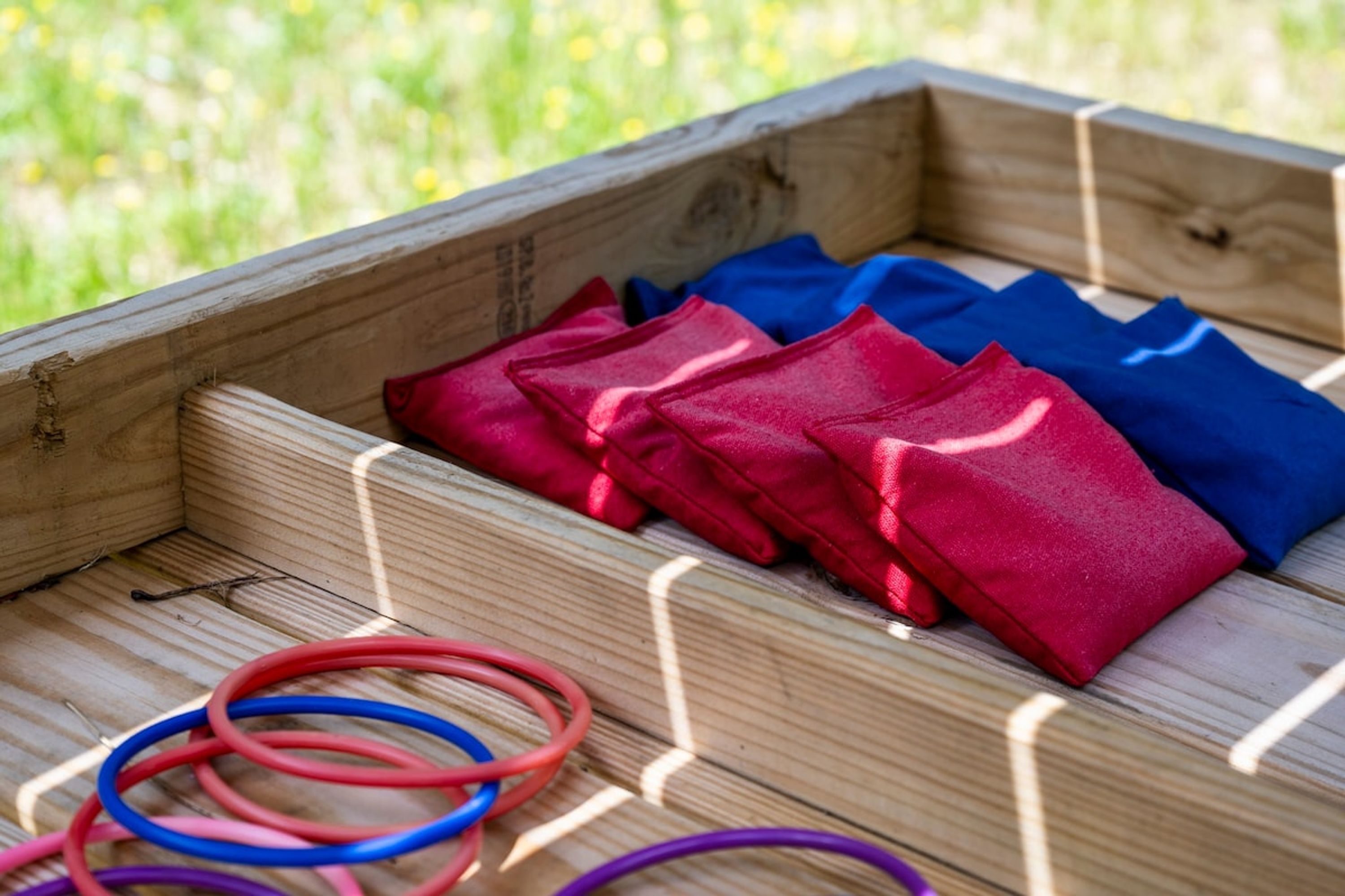 Een houten kist met rode en blauwe stoffen items erin.