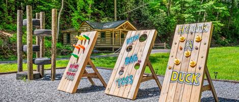 Organización de un juego de mesa de madera con letreros que dicen 'RING TOSS', 'BAG TOSS' y 'DUCK'.