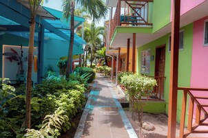 Un sendero bordeado de vegetación y edificios con balcones.