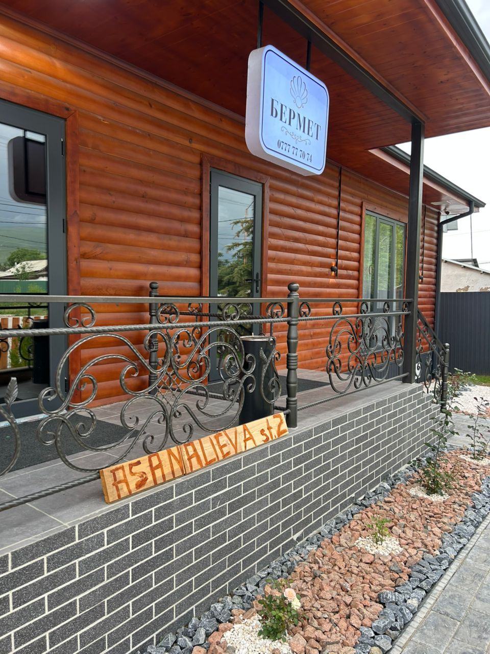 Un bâtiment en bois avec une enseigne indiquant « BEMPET » et une plaque nominative « ASHNA LIEVA, rue 2 ».