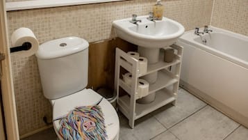 Un baño con inodoro, lavamanos y bañera.