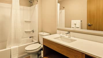 A bathroom with a bathtub, toilet, and sink.