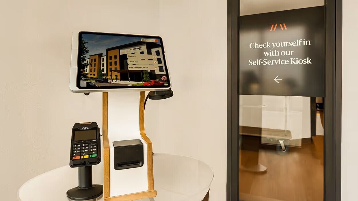 A self-service kiosk with a digital display and a payment terminal.