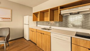 Una cocina moderna con armarios de madera, lavavajillas integrado y pileta de acero inoxidable.