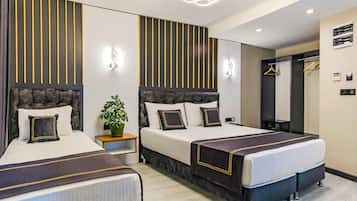 Ein Hotelzimmer mit zwei Betten, einer Zimmerpflanze, einem Spiegel und einer Pendelleuchte.