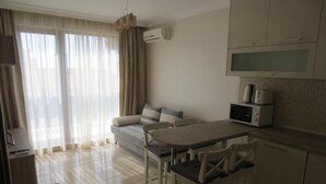 A compact living space with a kitchenette, a dining area, and a sofa. - Porto Paradiso Apartments (Sveti Vlas)