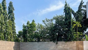 A swimming pool with lounge chairs, surrounded by a wooden deck and a stone wall.