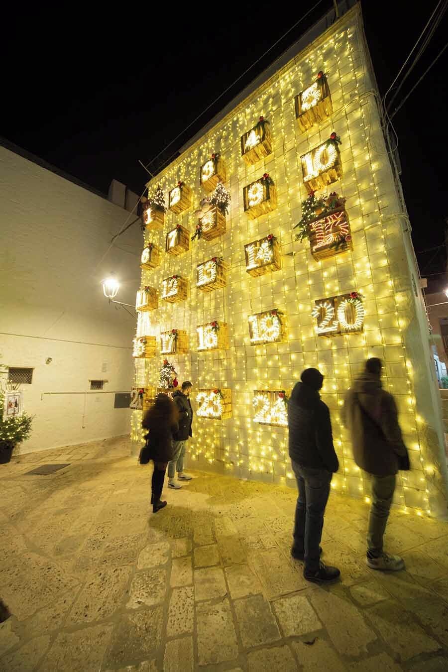 A building facade with illuminated windows displaying numbers, likely indicating room numbers or floors.