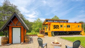 Un bâtiment à l’effigie d’un train, avec une façade en bois, une porte et un petit porche.