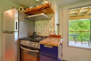 Una cocina compacta equipada con refrigerador, estufa, horno y encimera de madera.