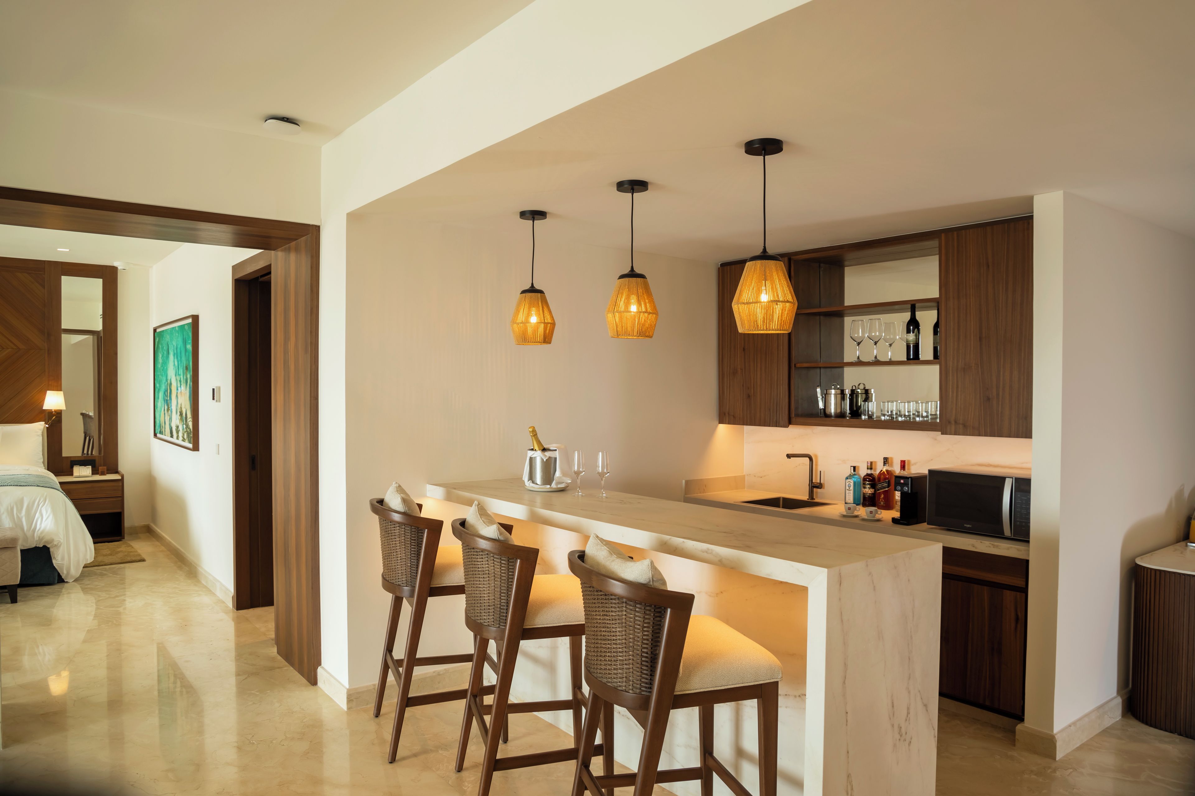 Una cucina moderna con zona bar, sedie in legno e illuminazione a sospensione.